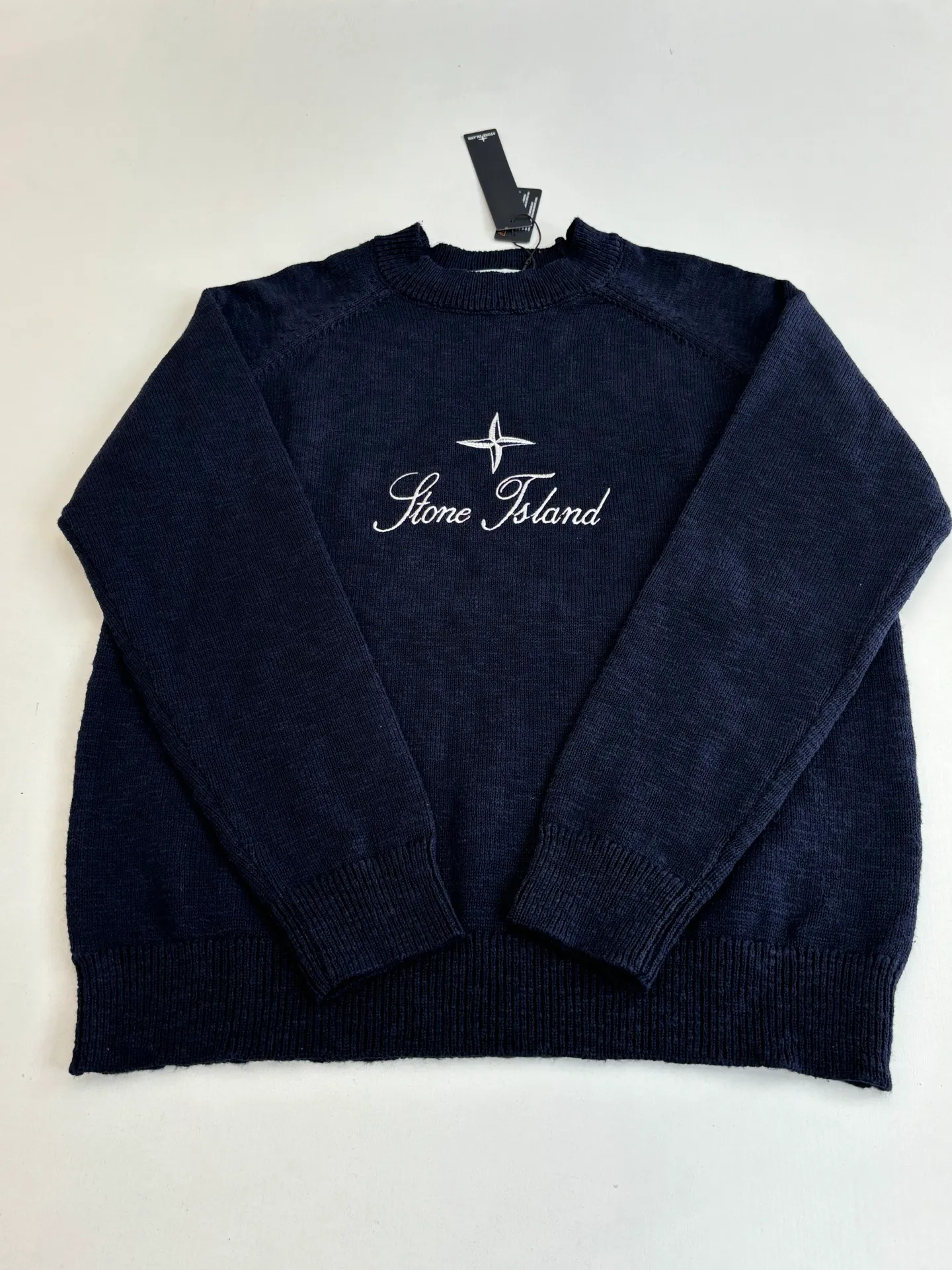 P460 STONE ISLAN*/Stone Island FW25 Holiday Limited Threaded logo embroidered pullover knitted sweater. The fabric is made of imported ultra-fine merino wool yarn, which has been combed to remove impurities and anti-pilling. The plain base is woven with a 14-needle circular machine. The yarn is first dyed and then woven to make the navy blue color rich and not easy to fade. The body is designed with a raglan sleeve structure, the shoulder panels are laser positioned and cut, and the splicing joints are seamlessly connected using embedded clip technology, giving you a non-restrained feeling when worn. The brand logo and star pattern on the chest adopt a combination of hand-applied embroidery + flat embroidery, using high-elastic polyester-cotton thread. The stitch density is controlled at 8 stitches per centimeter. The outline of the pattern is clear and three-dimensional, and it is wear-resistant and does not fall off. The neckline is designed with a ribbed round neck. The rib tissue is pre-shrunk and shaped by high temperature. It has excellent resilience and is not easy to loosen. The cuffs and hem are also ribbed with the same material, and are reinforced with the body through overlock sewing technology. The overall tailoring follows ergonomics, and each process undergoes quality control testing. From yarn weaving to finished product sewing, the precision of details is controlled throughout the process to create knitted items with both functionality and design. The overall wiring is straight and delicate, the fabric is comfortable and soft, and the color is consistent without color difference. Size: S/M/L/XL